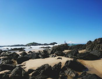 Scenic view of beach against clear blue sky