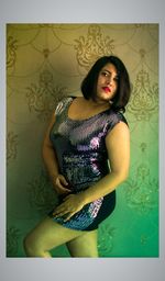 Beautiful young woman standing against wall