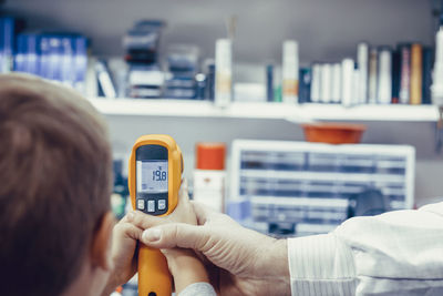 Close-up of kid measuring heat with infrared thermometer in a workshop.