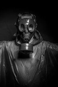 Man wearing gas mask against black background