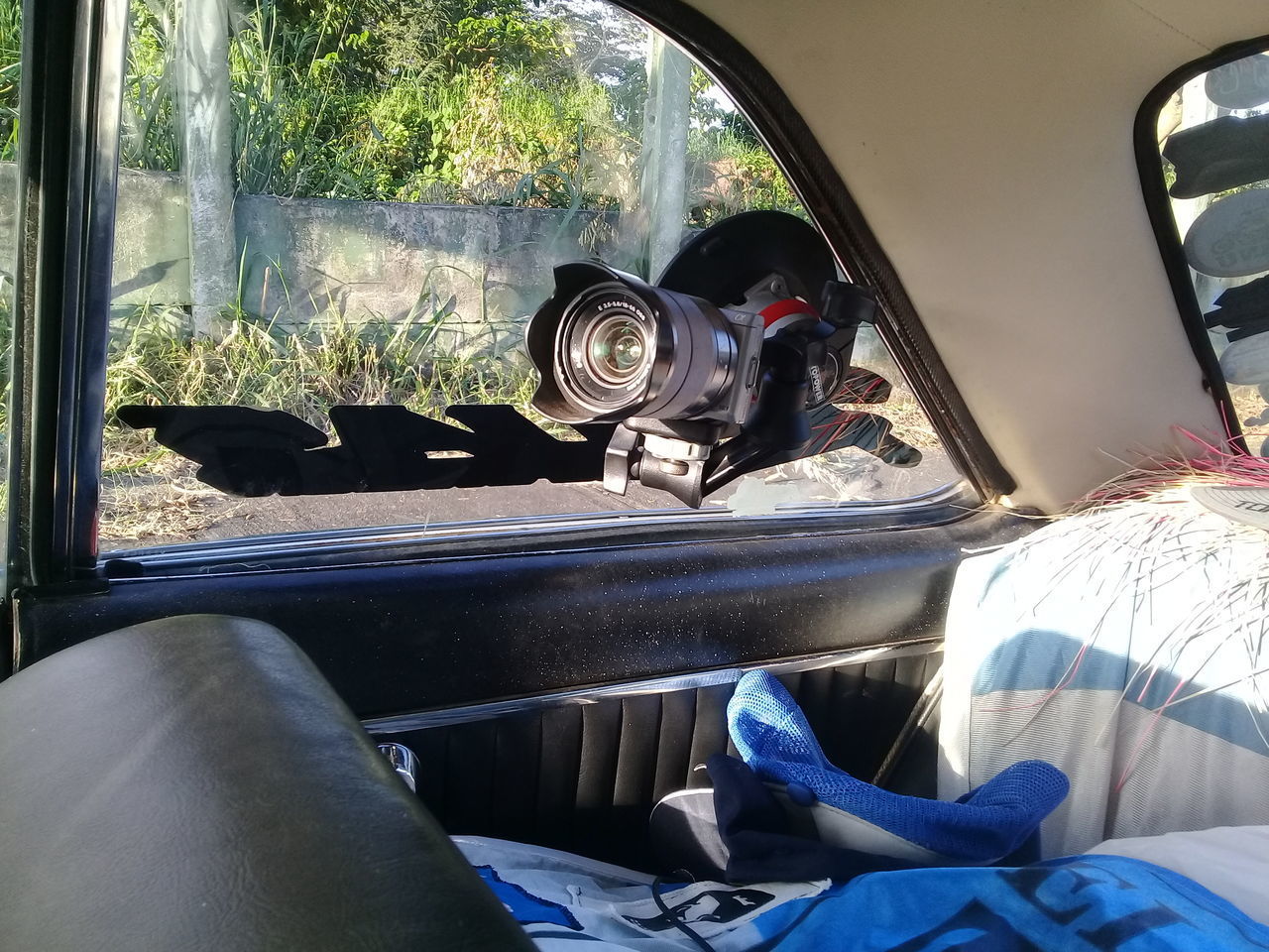 MAN PHOTOGRAPHING WHILE SITTING ON CAR WINDOW