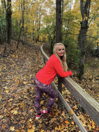 Portrait of smiling woman in forest during autumn