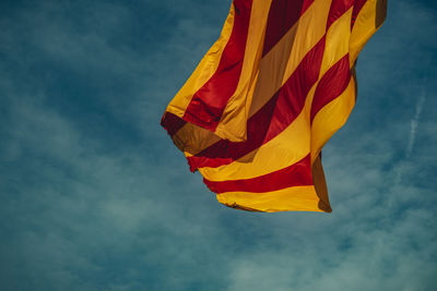 Low angle view of flag waving against sky