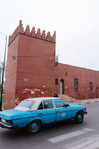 Car on street against buildings in city