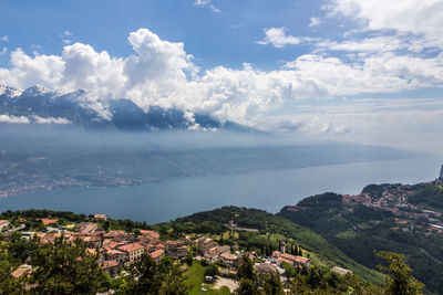 Aerial view of townscape by sea against sky