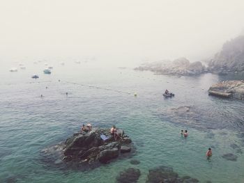 High angle view of people enjoying in sea during summer