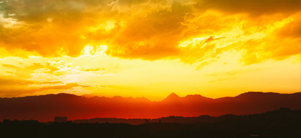 Scenic view of silhouette mountains against sky during sunset