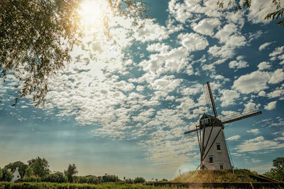 Canal with old windmill and sunlight near damme. a charming country village in belgium.