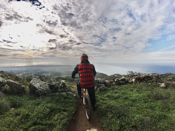 Rear view of man looking at sea against sky