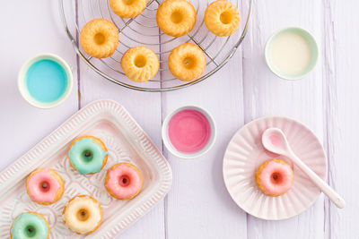 Directly above shot of multi colored donuts with syrups and spoon