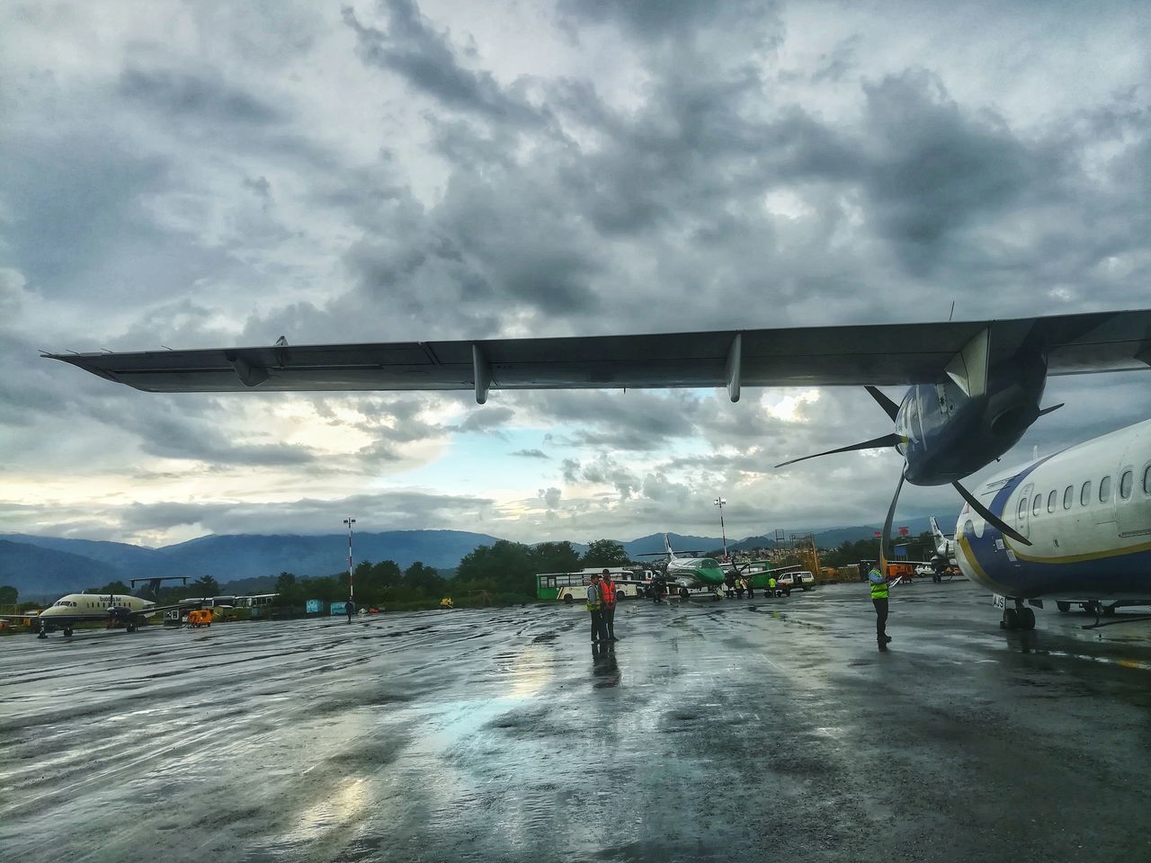 cloud - sky, transportation, air vehicle, sky, airplane, mode of transportation, nature, travel, airport, overcast, day, airport runway, outdoors, mountain, storm, real people, men, people, aerospace industry