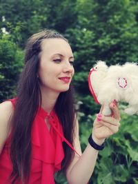 Woman looking at toy against plants