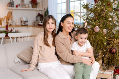 Family spends time together during christmas holidays in decorated house.