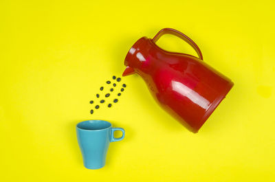 High angle view of coffee cup on yellow background