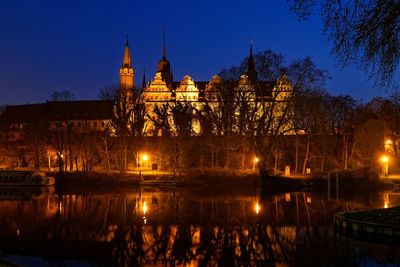 Illuminated buildings against sky at night