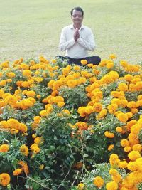 Portrait of man standing on yellow flower field