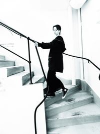 Side view of young man standing on staircase