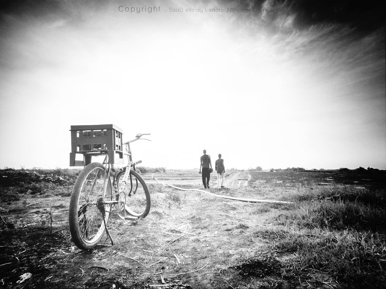 bicycle, transportation, land vehicle, mode of transport, lifestyles, men, field, sky, leisure activity, landscape, full length, grass, riding, dirt road, day, outdoors, road, stationary