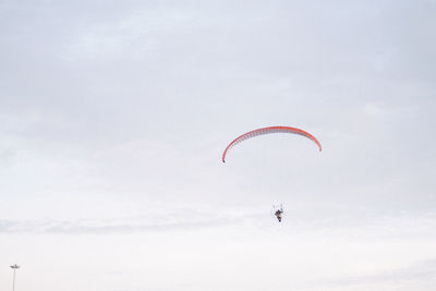 Low angle view of person paragliding against sky