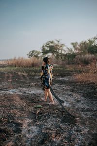 Side view of man walking on land against clear sky