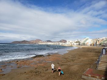 People at beach against sky