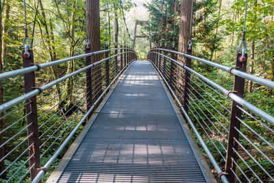 Footbridge amidst trees in forest