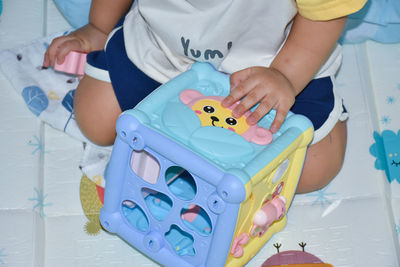 High angle view of baby boy sitting on toy car