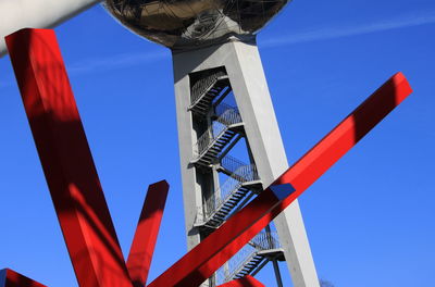 Low angle view of telephone pole against clear blue sky