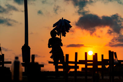 Silhouette of people and crosses fixed on the ground in honor of those killed by covid-19. 