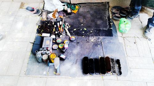 Low section of man standing by shoemaker equipment on street