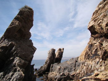 Rock formations in sea against sky