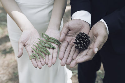Midsection of man holding hands standing outdoors