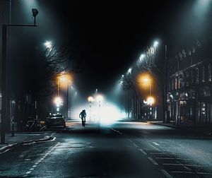 Illuminated foggy city street at night