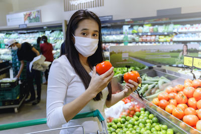 Portrait of woman buying vegetables at supermarket