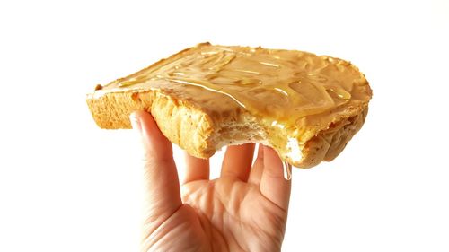 Midsection of person holding ice cream against white background