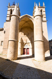 Exterior of historic building against clear blue sky during sunny day