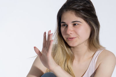 Portrait of beautiful young woman against white background