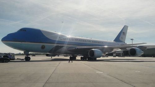 Airplane on airport runway against sky