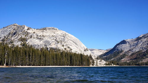 Scenic view of lake and mountains against clear blue sky