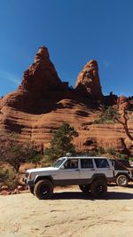 Car on desert against clear sky