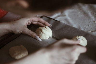 Close-up of hand holding dough on table