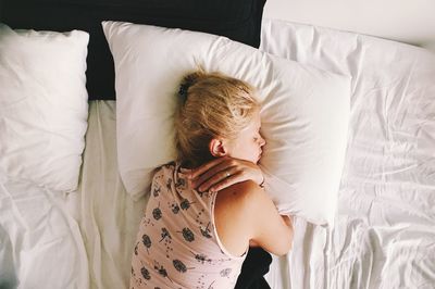 High angle view of woman relaxing on bed at home