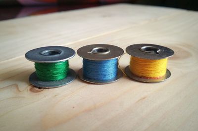 Close-up of multi colored thread spools on table