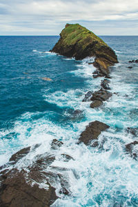 Scenic view of rocks in sea against sky