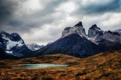 Scenic view of snowcapped mountains against cloudy sky