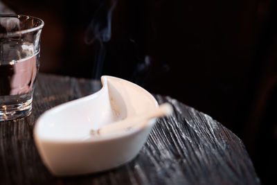 Close-up of cigarette in ashtray on table at cafe