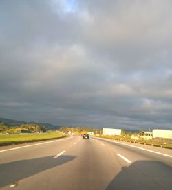 View of highway against cloudy sky