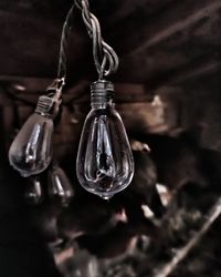 Close-up of light bulb hanging on table