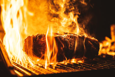 Close-up of meat on barbecue grill at night