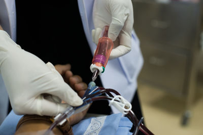 Midsection of nurse holding blood bag in hospital